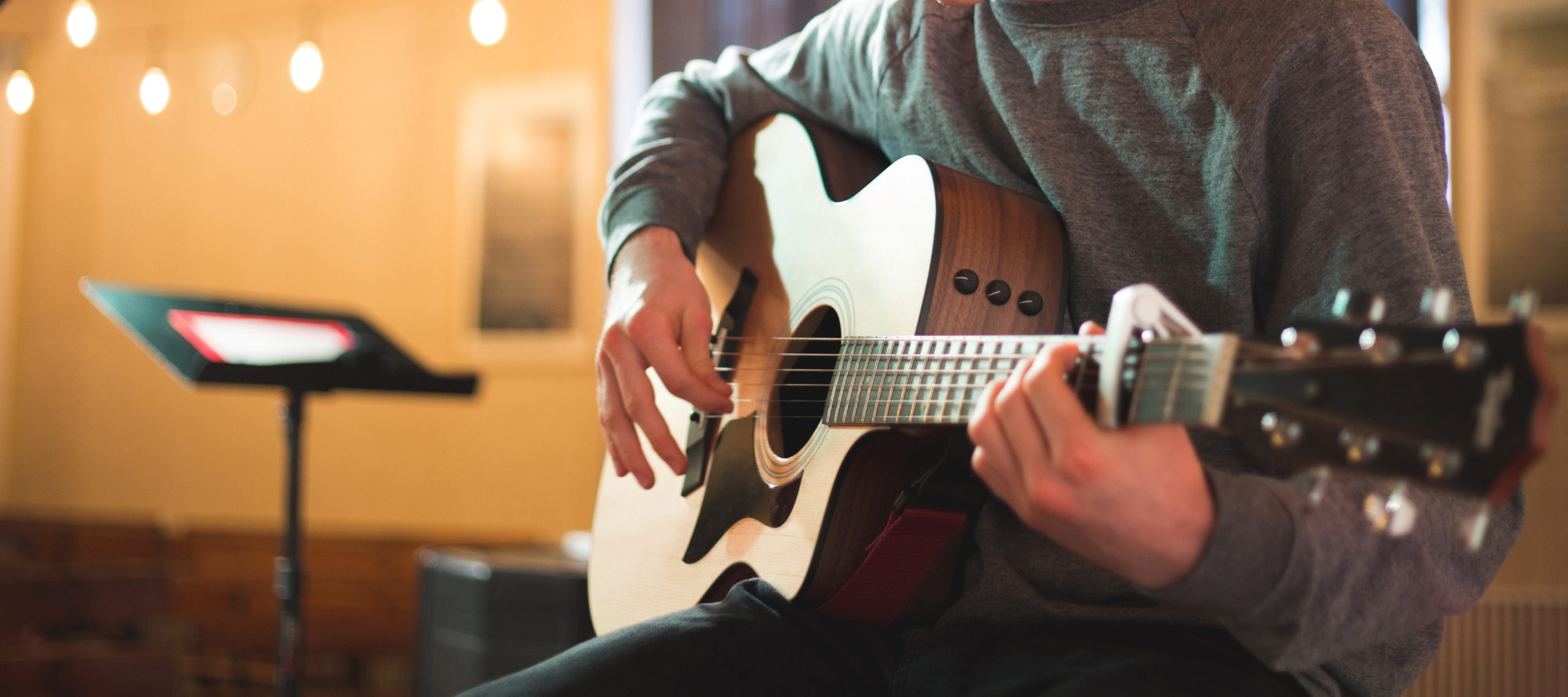Slider 1, picture of a male person playing a guitar